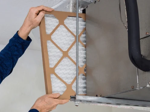 A professional HVAC technician performs maintenance on a central HVAC unit outside a home, with a toolbox of plumbing tools nearby, in a clean and well-maintained setting.