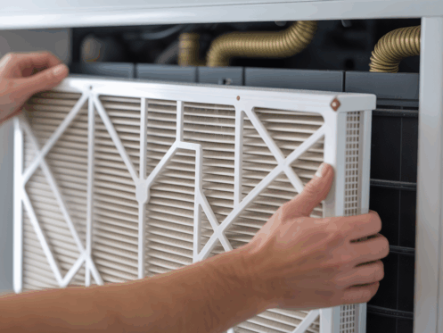 Close-up of an air filter being placed into a central HVAC system.