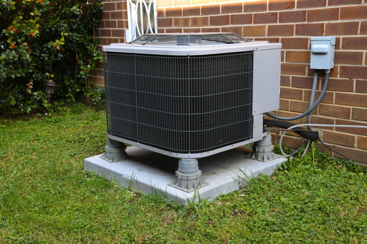 A well-maintained suburban Texas home with an air conditioning unit, lush lawn, and clear blue sky, symbolizing comfort and reliability.