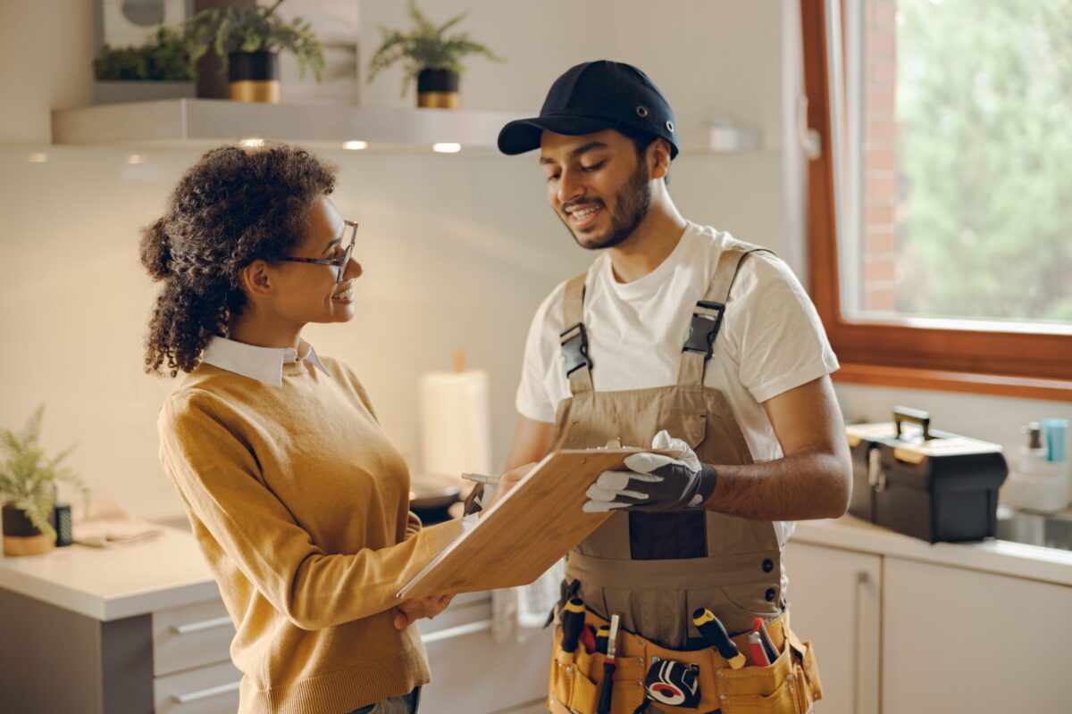 HVAC technician in a cozy home with warm lighting and subtle plumbing fixtures, set in a suburban Texas neighborhood, discussing how to prevent air handler unit leaking water.